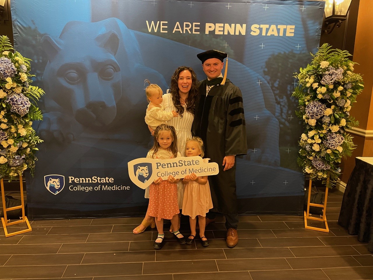 Aidan Hintze, MD, poses with his wife and three daughters at his medical school graduation.
