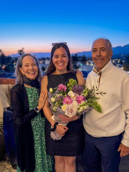 Leana Nápoles, MD, poses with her parents at her residency graduation.
