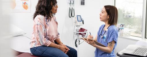 Female nurse makes notes while talking with the patient